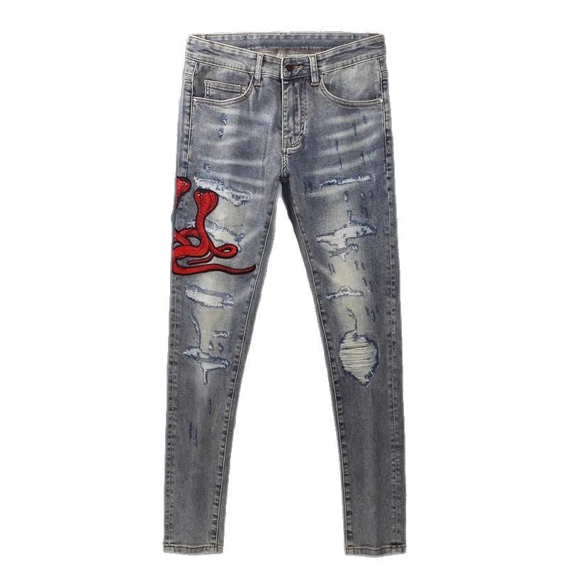 Old colour slim fit jeans with hole patches and embroidered detailing on worn cotton fabric