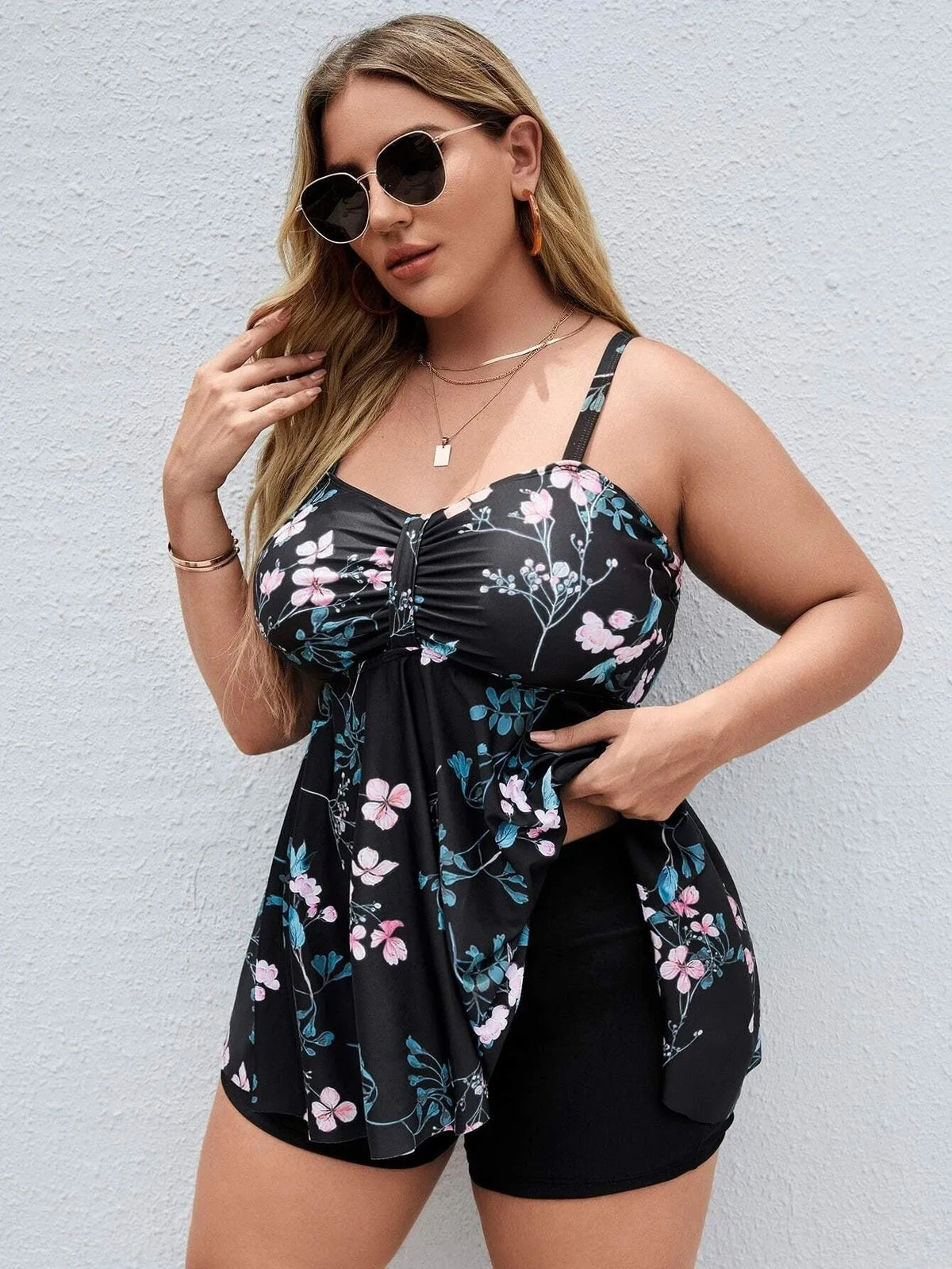 Women's floral print one-piece swimsuit on a hanger, showing split colour design and plus size fit.