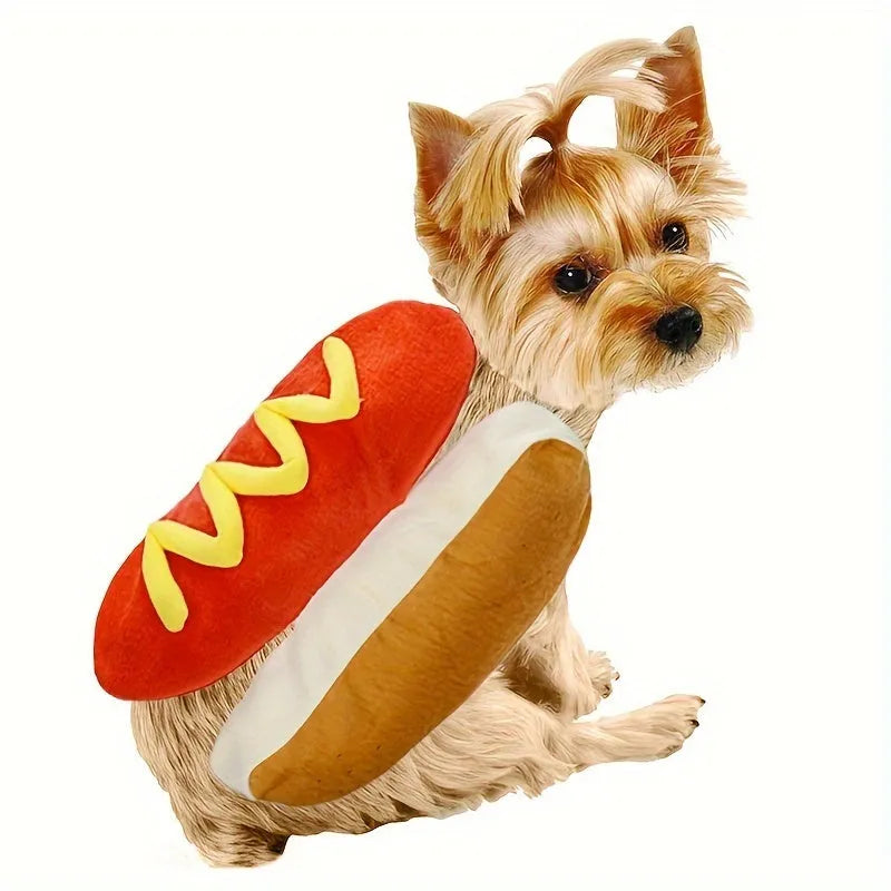 Small dog wearing a red and brown plush hot dog costume with bun and sausage design.