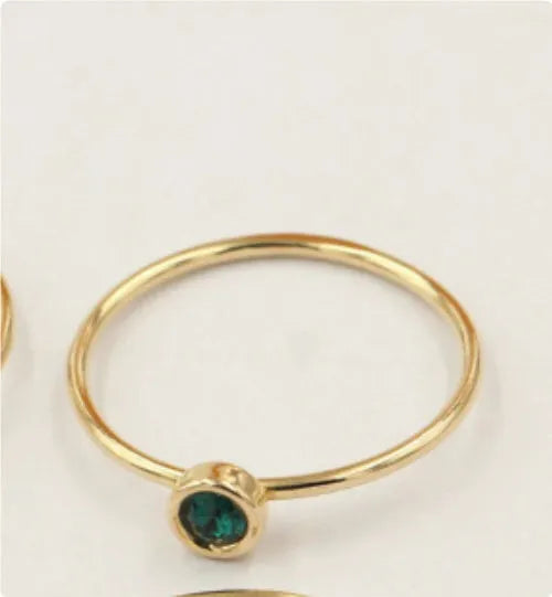 Copper knuckle ring with gold gild and coloured GF zircon stones on a finger.