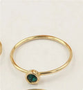Copper knuckle ring with gold gild and coloured GF zircon stones on a finger.
