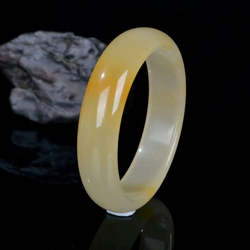 Polished light jade stone bracelet for women on a white background, showing Chinese style and smooth finish.