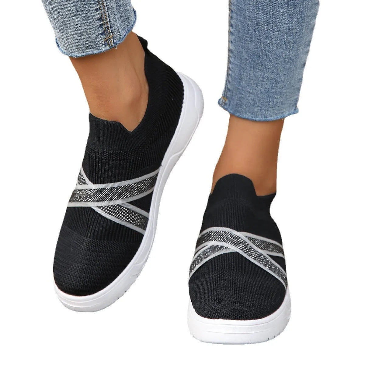 Women's black casual shoes with fabric mesh upper and flat rubber sole on neutral background