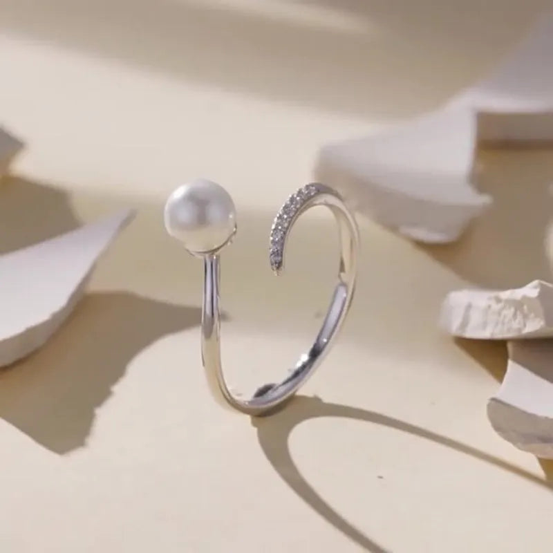 Adjustable open loop S925 sterling silver ring decorated with white shell pearls.
