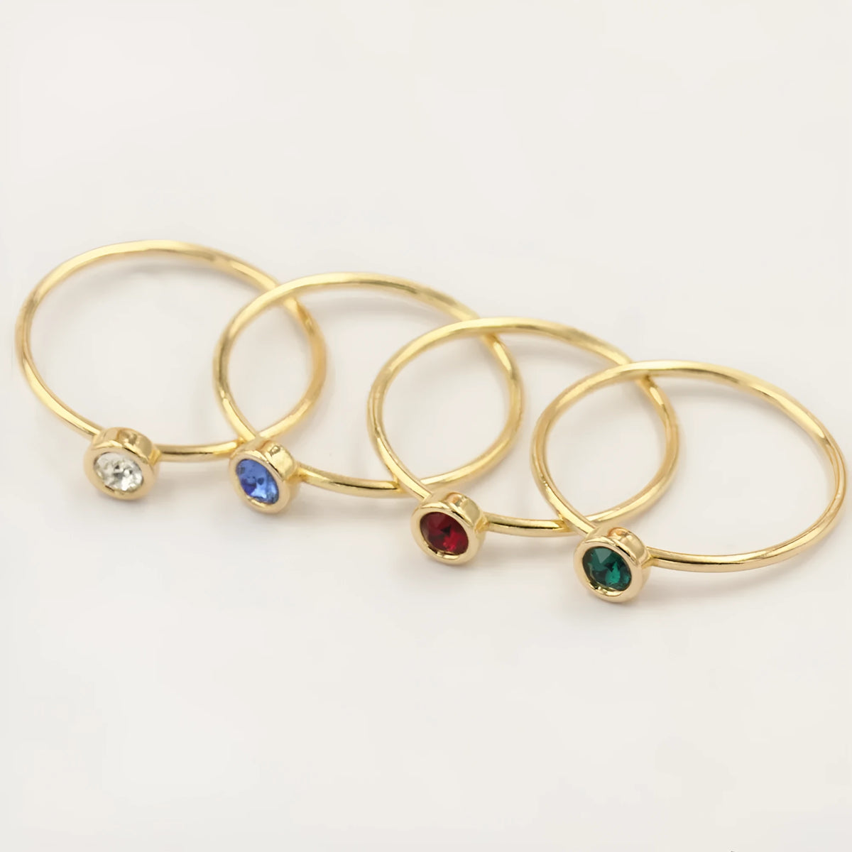 Copper knuckle ring with gold gild and coloured GF zircon stones on a finger.