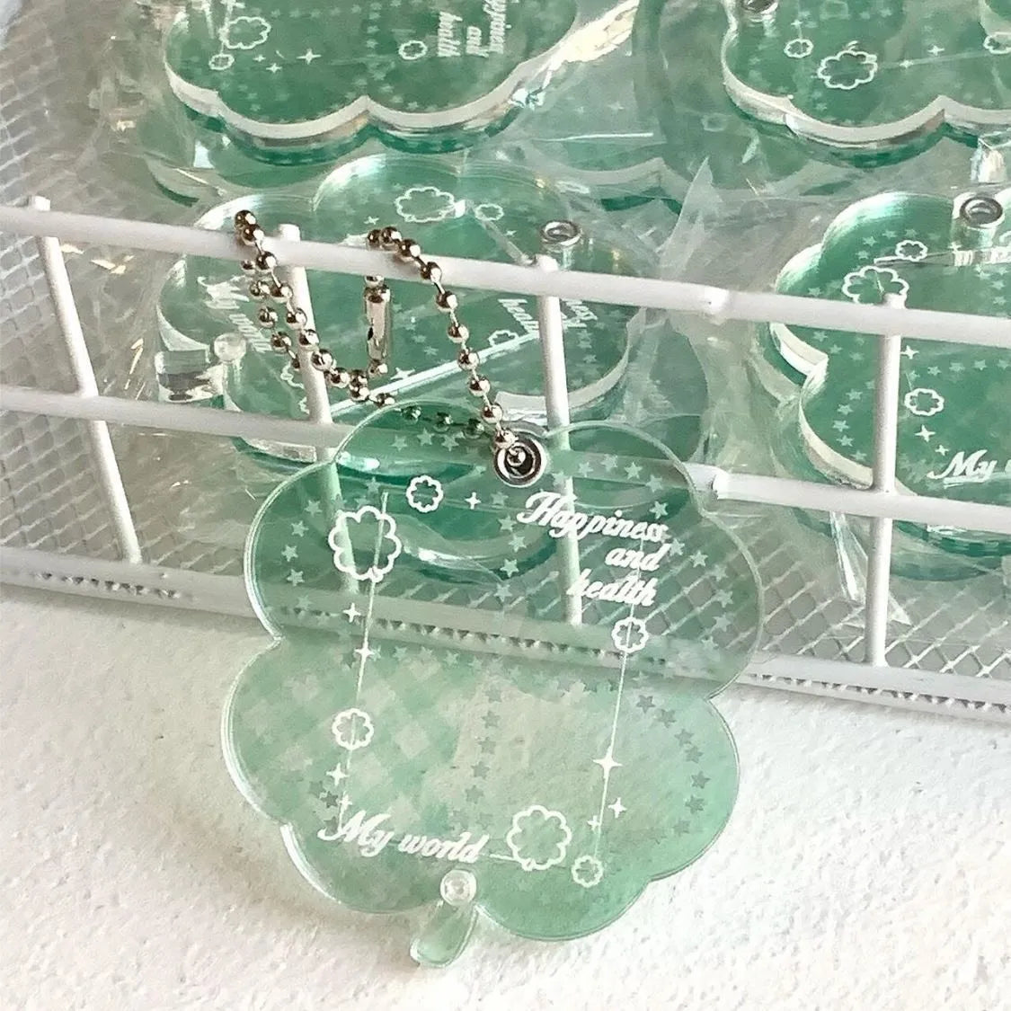 Four-leaf clover shaped acrylic phone pendant keychain in blue, green, and mint colour variations
