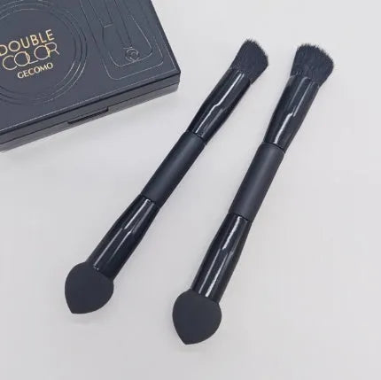 Elegant black double-headed makeup brush with miter sponge and angled concealer heads on a wooden handle.