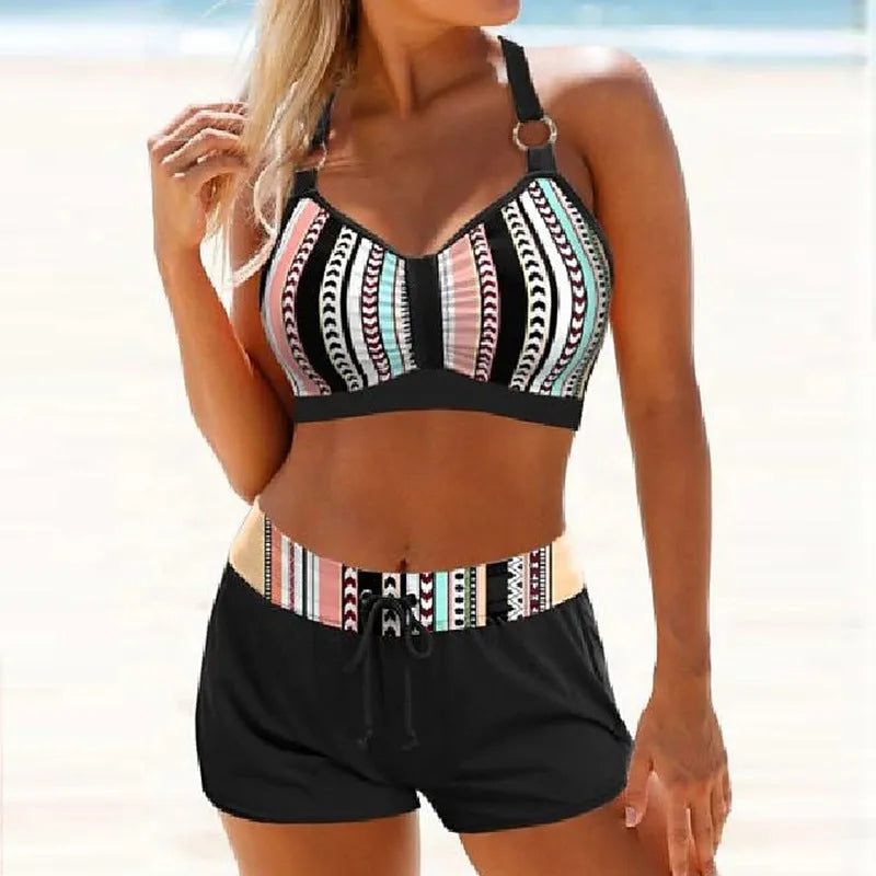 Women's navy blue and print polyester two-piece bikini swimsuit on a hanger.