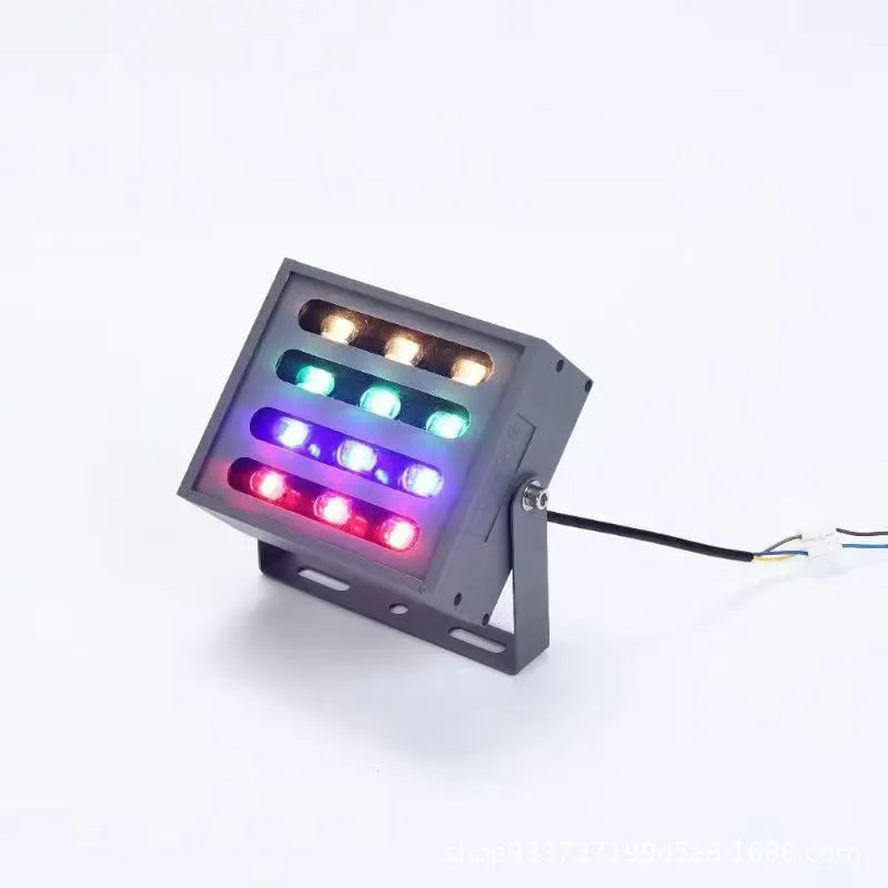 Silver aluminium alloy outdoor LED spotlight projecting multicoloured light onto a tree.