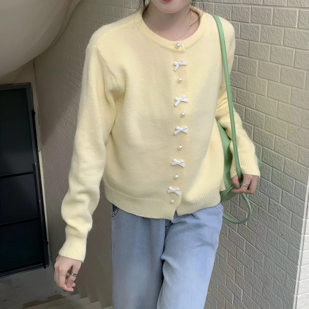 Women's light blue cashmere blend cardigan sweater with pearl buttons and bow detailing on front