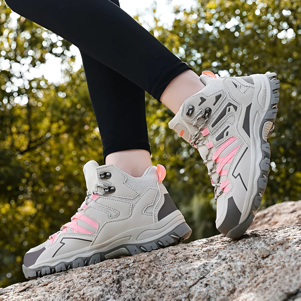 Hiking sneaker with flannel upper and rubber sole in black, shown on a rocky outdoor path.