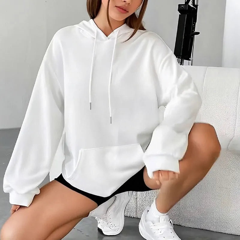 A woman wearing a loose grey drawstring hooded sweatshirt with a front pocket, showing the relaxed fit.