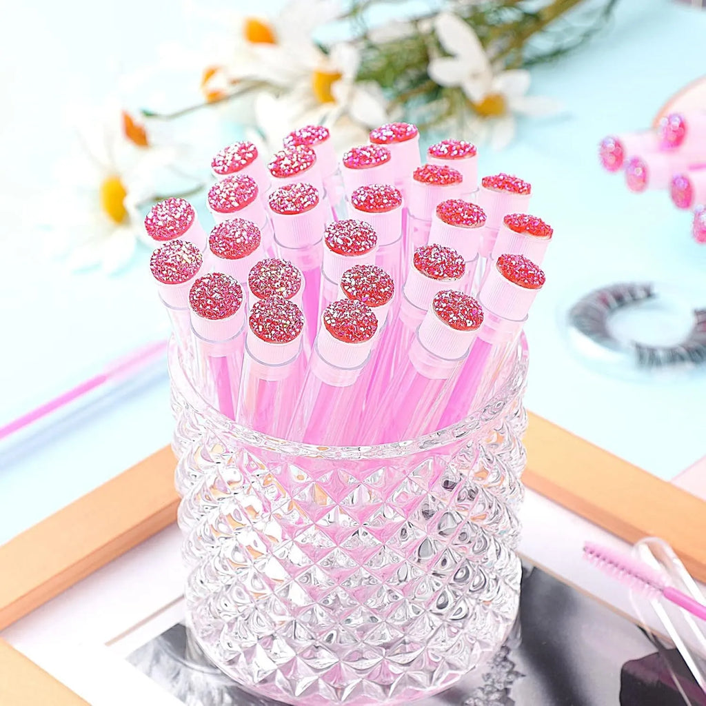 Set of coloured disposable eyelash brushes stored in clear plastic tubes for mascara and lash care