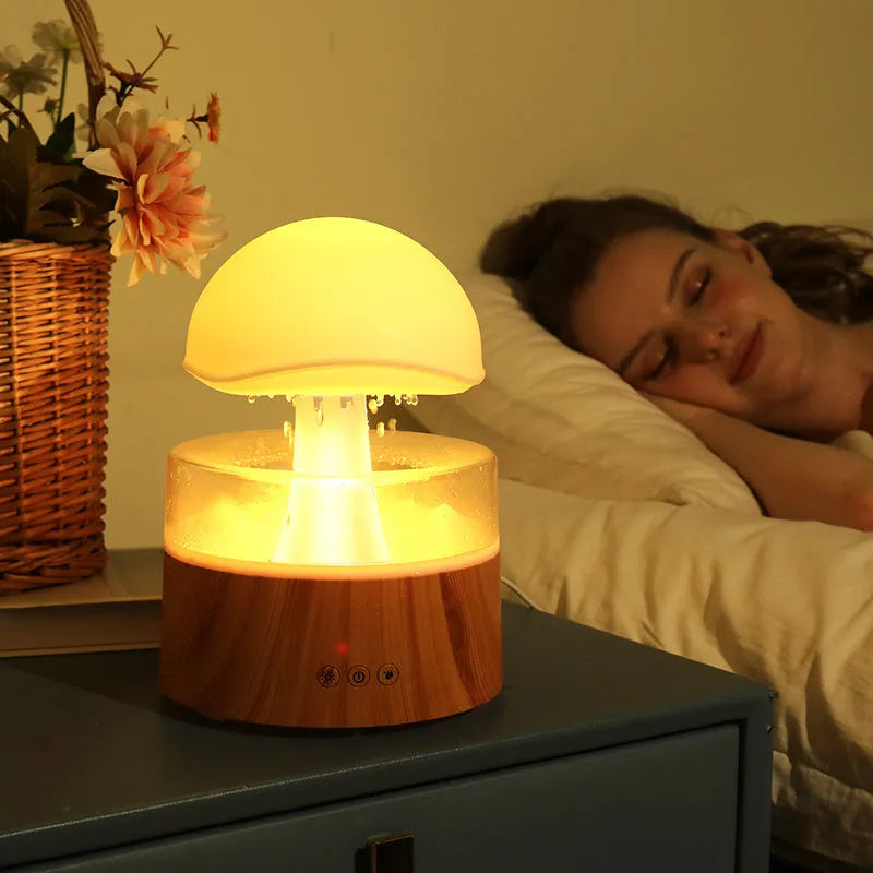 White cloud-shaped humidifier and aroma diffuser with simulated raindrops and coloured night light
