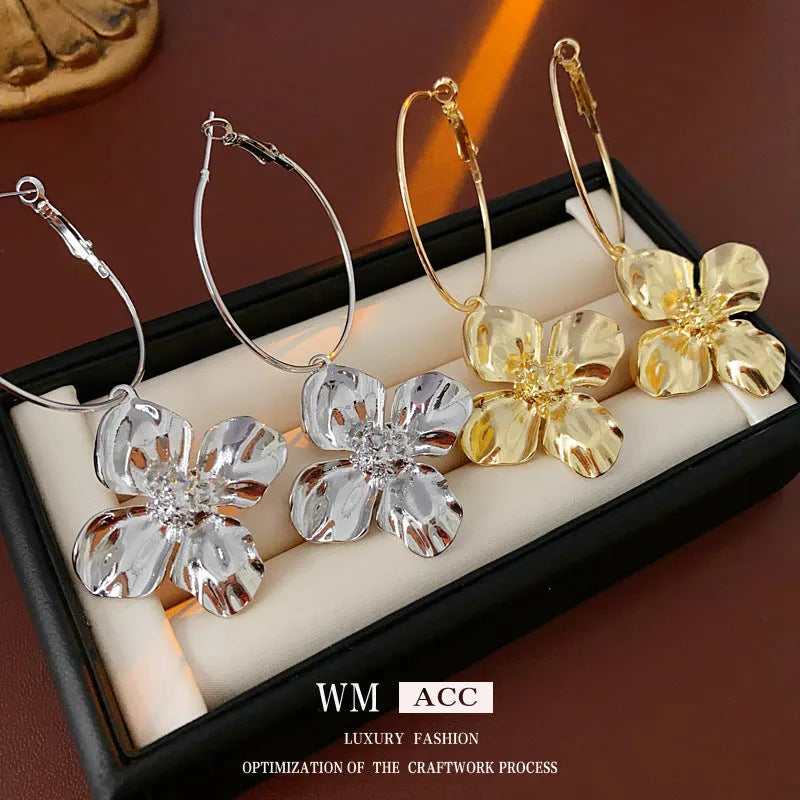 A pair of silver needle metal flower earrings with a geometric design in a gold or silver colour.