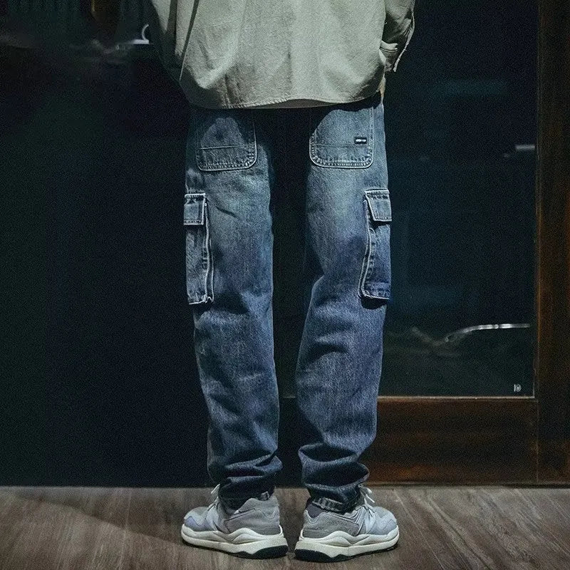 Man wearing blue loose straight-leg retro jeans with a zip fly, shown in a casual setting.