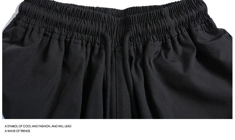 Men's black quick-drying sports shorts with elastic waistband and loose straight-leg design