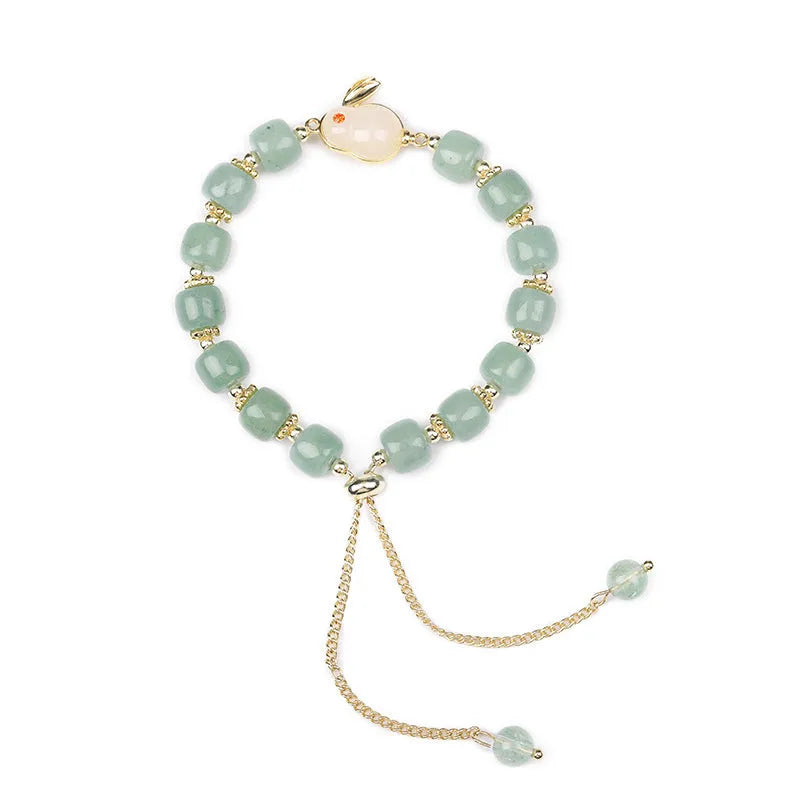 Rabbit charm bracelet with green aventurine and strawberry quartz stones on a gold or copper chain.