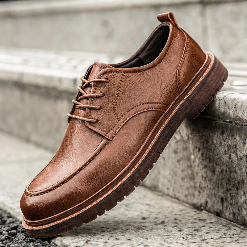 Black and brown round-toe casual leather shoes with visible stitching and flat rubber soles.