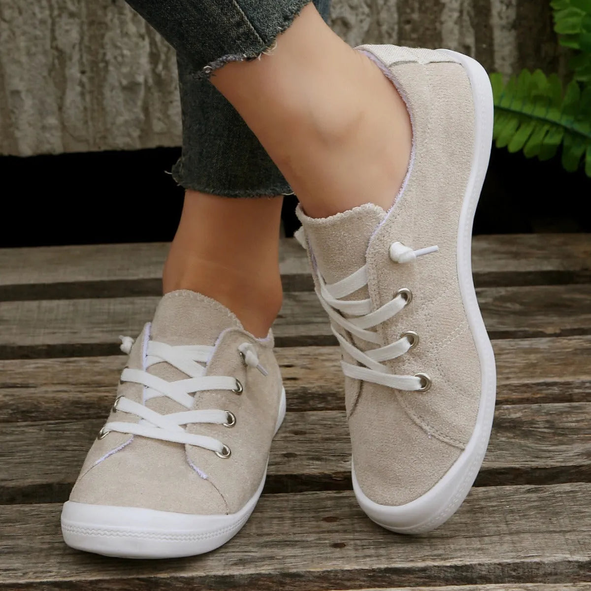Women's creamy-white low-top fabric sneaker with rubber sole shown from side view