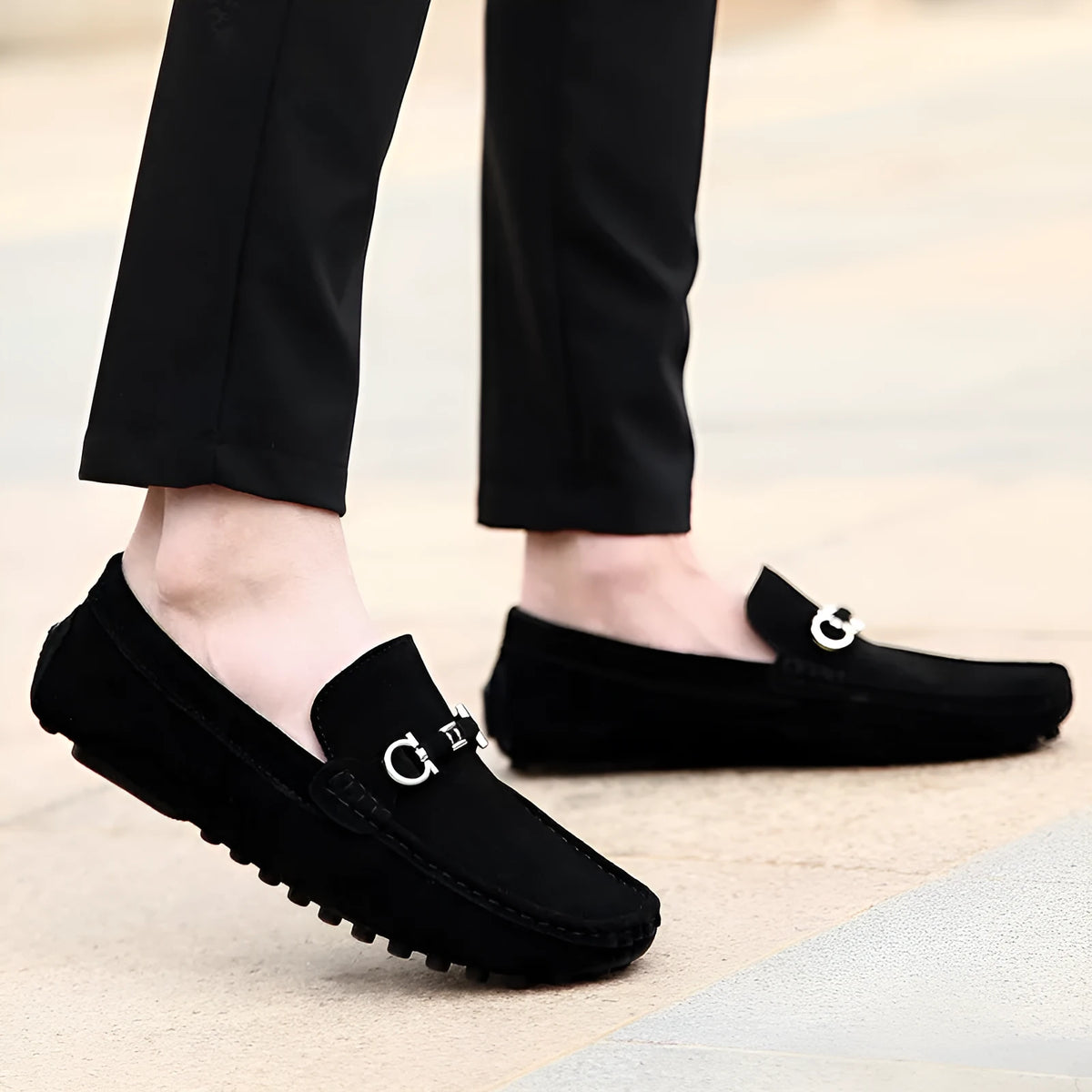 Men's black slip-on leather shoes with a square toe and matte finish on a plain background.