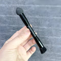 Black concealer brush with sponge tip and wooden handle for dark circle application