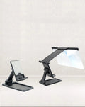 Black folding mobile phone screen amplifier with detachable holder, shown magnifying a smartphone display.