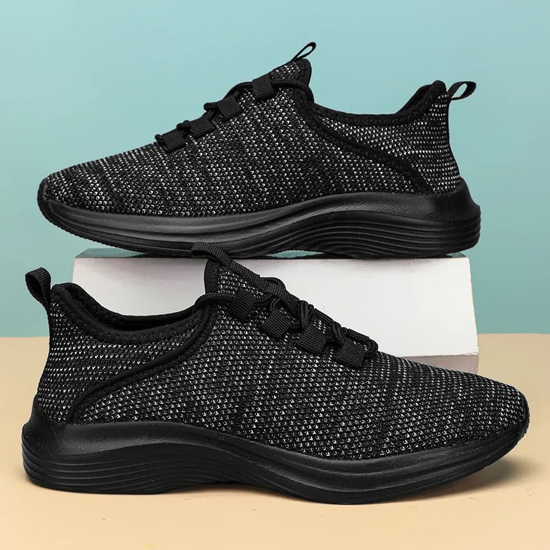 Women's low-top casual sneaker in mesh fabric with round toe and flat sole, shown in black.