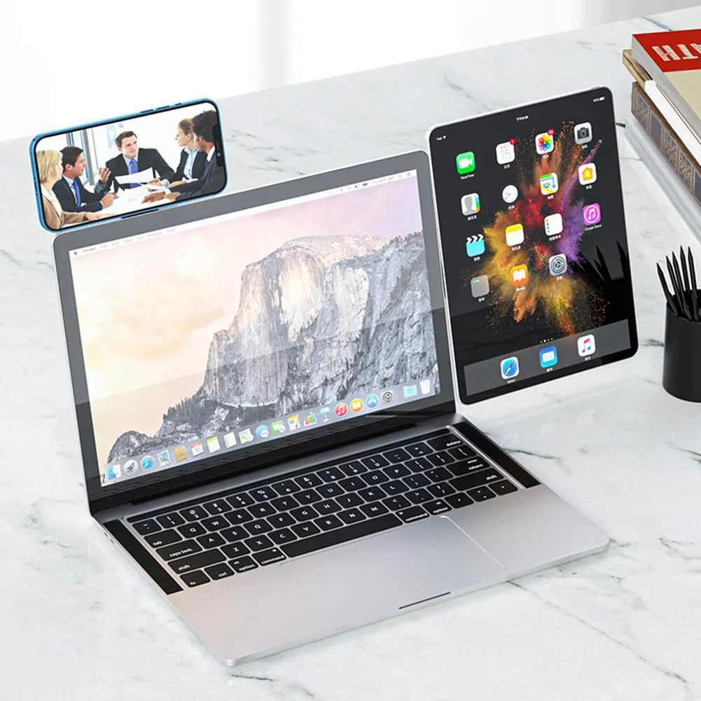 Black adjustable magnetic phone holder clipped to silver laptop showing phone mounted beside screen