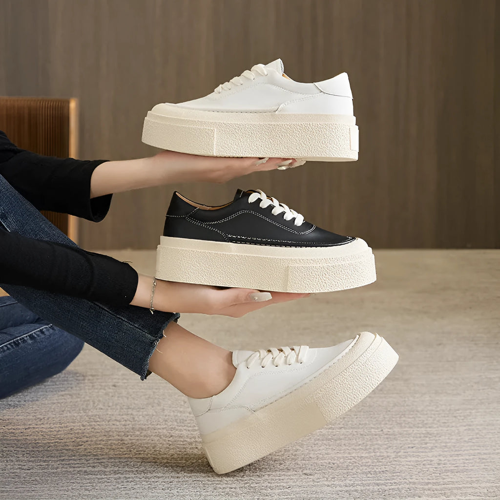 Women's black embossed leather platform sports shoes with a round toe and rubber sole.