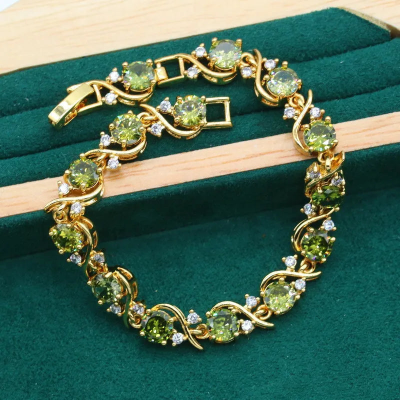 Olive green zircon jewellery set with snake bones chain necklace, matching earrings, and ring on a copper base.