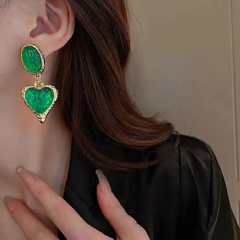 Pleated oval heart-shaped alloy stud earrings on silver posts in purple, red, green, and yellow/white colours.