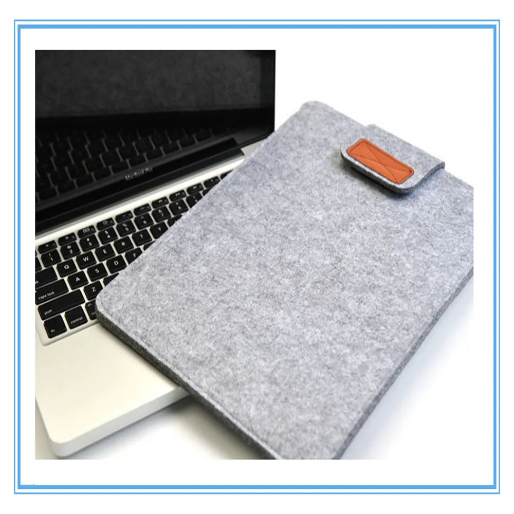 Dark grey clamshell laptop bag made of woven plush material, shown open to reveal the internal computer compartment.