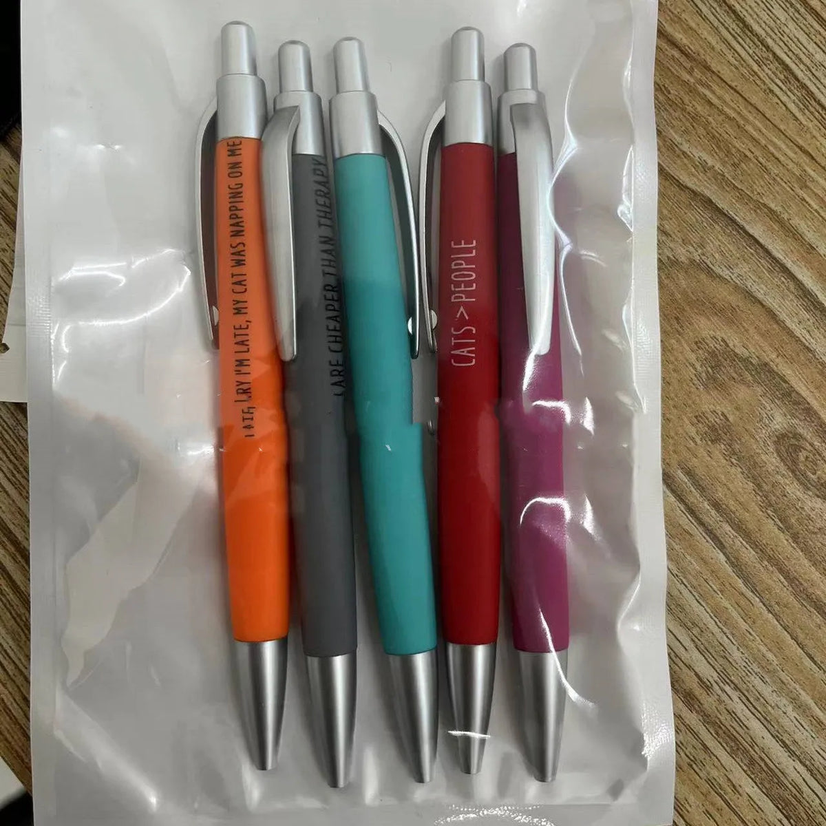 Coloured push action automatic pen set with cat and dog themed refills in beaded storage bag