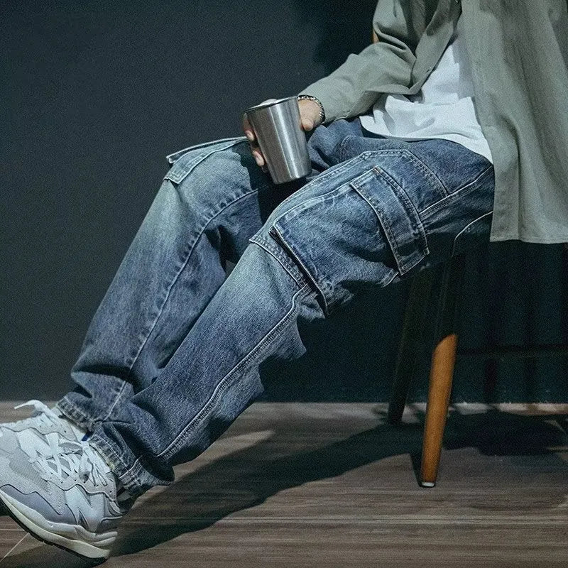 Man wearing blue loose straight-leg retro jeans with a zip fly, shown in a casual setting.