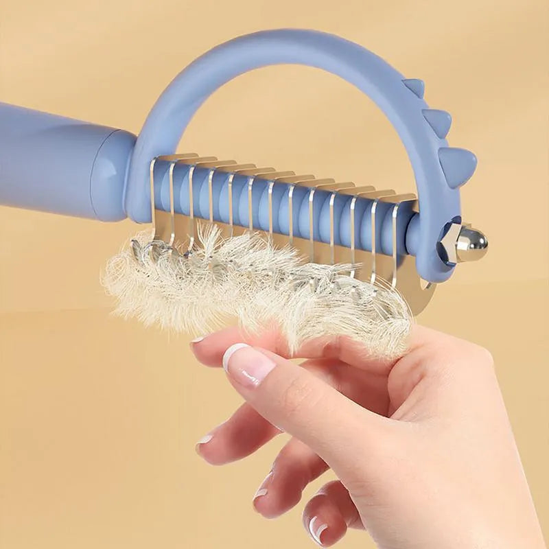 Blue dinosaur-shaped cat brush with double-sided stainless steel bristles and self-cleaning mechanism
