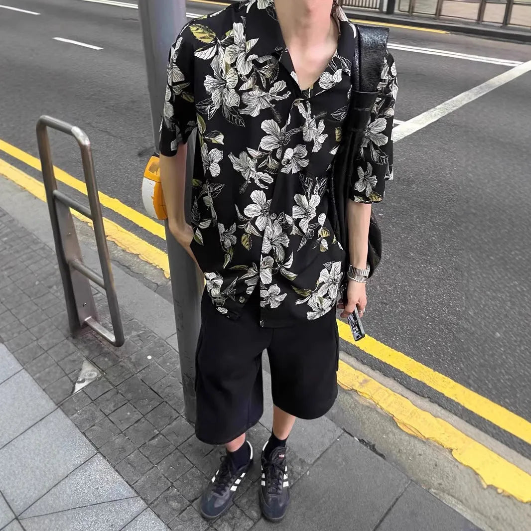 Black men's ice silk shirt with floral print, Cuban collar, and short sleeves on a hanger.
