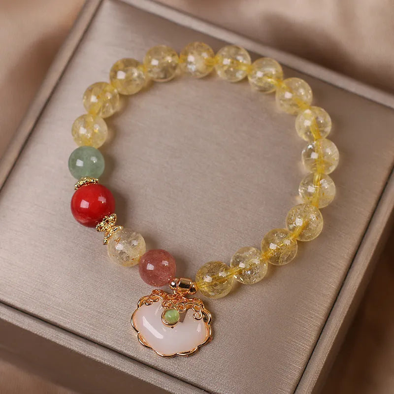 Close-up of a women's bracelet with a yellow citrine jade ruyi pendant on an adjustable alloy chain.