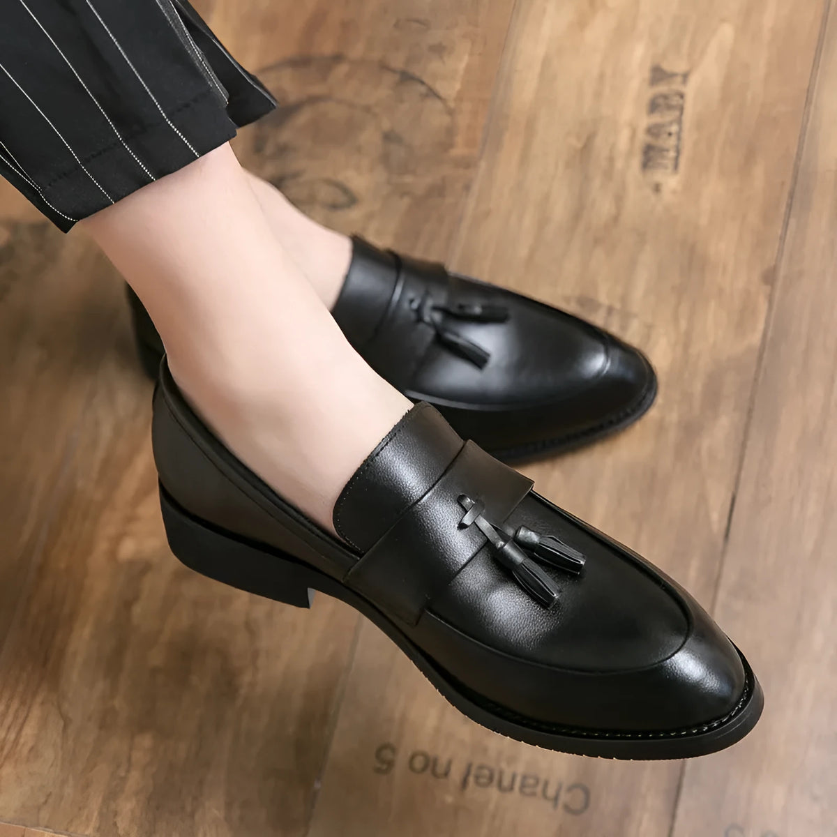 Men's black business casual slip-on shoes with tassel detail and rubber sole