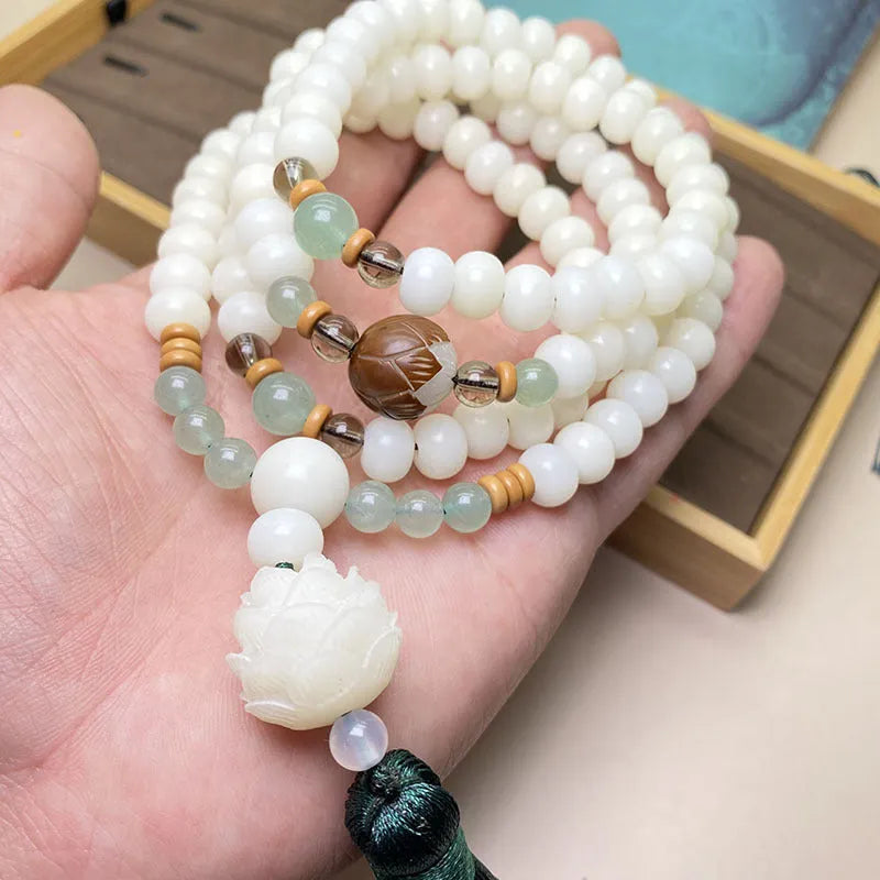 Close-up of a white jade Bodhi bead bracelet with 108 beads, showing different style patterns.