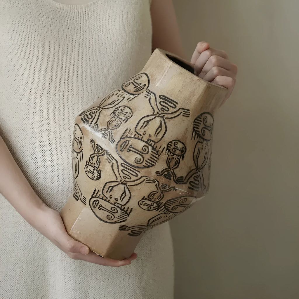 Hand-painted ceramic cylindrical vase with carved religious patterns in tribal totem flower design