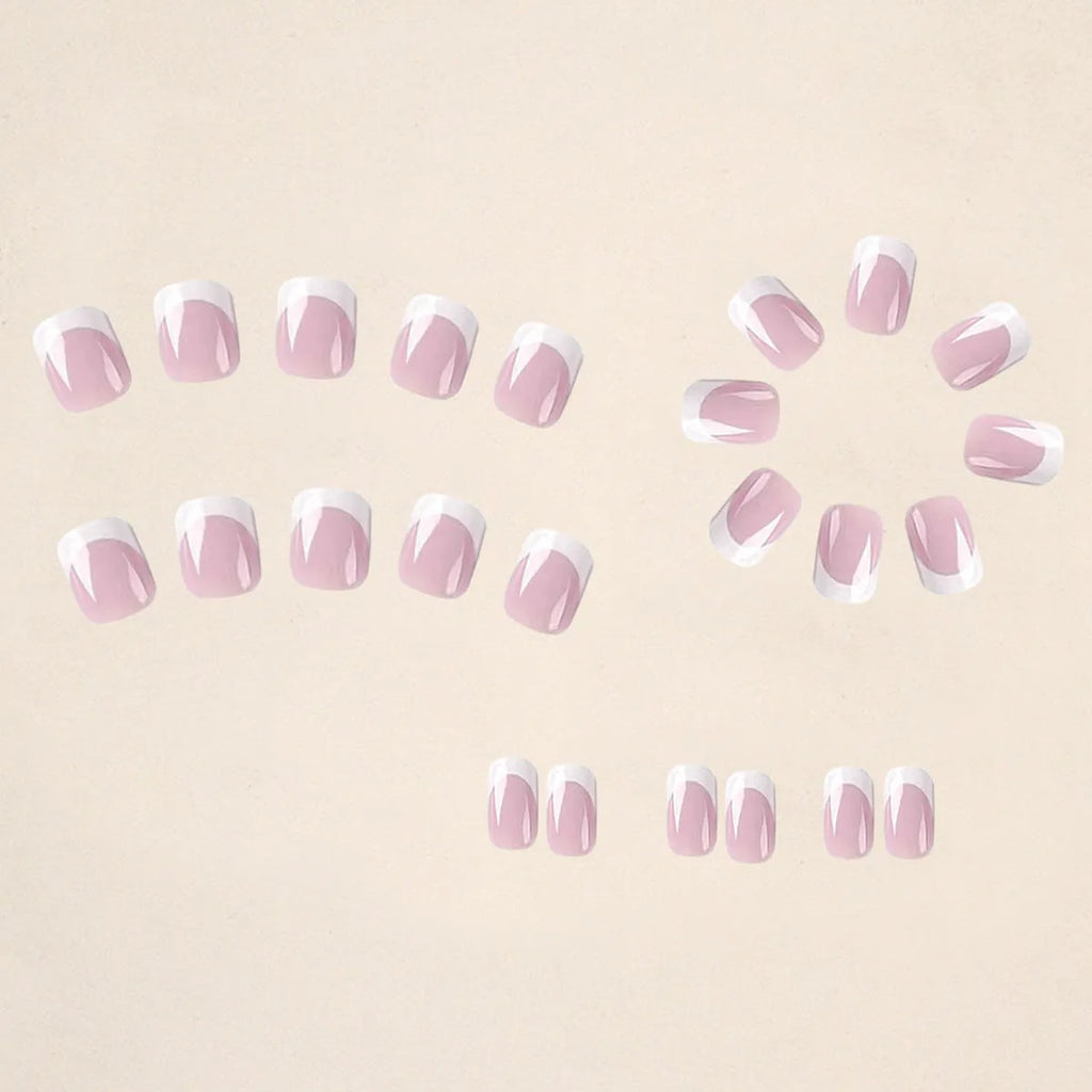 24 white plastic fake nails with a black and grey plaid pattern, arranged on a table.
