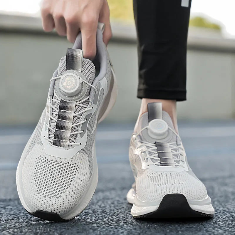 Men's low-top running shoes in beige with a rotating buckle and mesh upper, shown on a white background.
