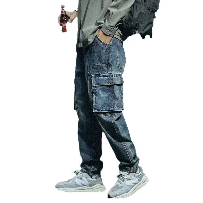 Man wearing blue loose straight-leg retro jeans with a zip fly, shown in a casual setting.