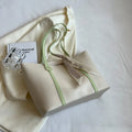 Women's soft bucket shoulder bag in various colours showing crossbody strap and zippered compartment