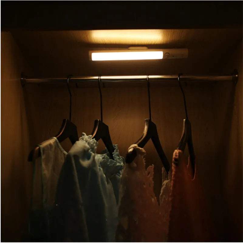 Long white LED human body induction cabinet light with magnetic strip on back for wall or wardrobe mounting.