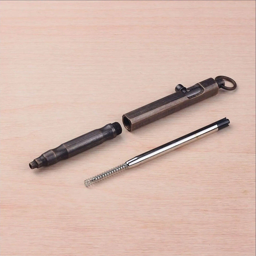 Brass tactical pen with hexagonal bolt design and machine gun aesthetic on a dark background.