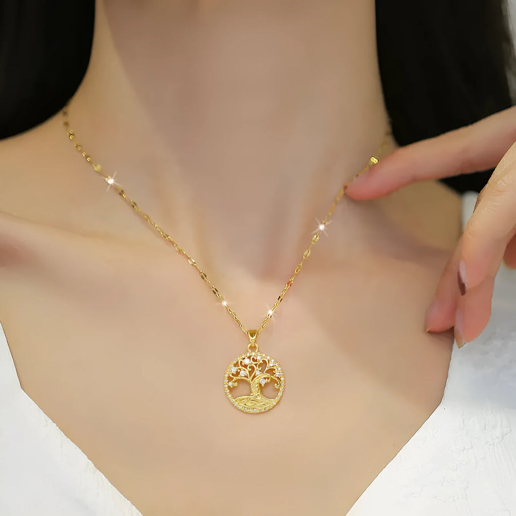 Gold-plated necklace with rhinestone tree pendant featuring mother-of-pearl detail on adjustable lip chain