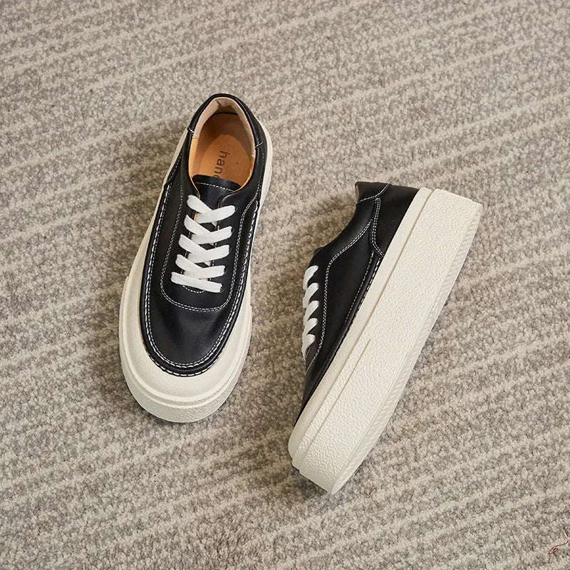 Women's black embossed leather platform sports shoes with a round toe and rubber sole.