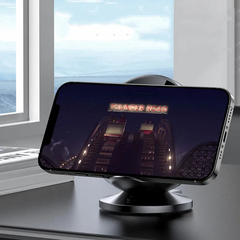 Black multifunctional wireless charging phone holder with integrated Bluetooth speaker on a desk